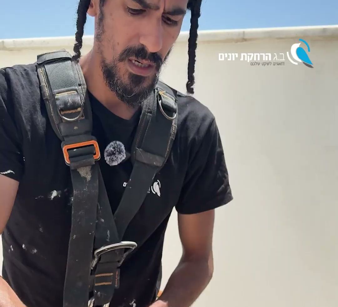 טכנאי חובש רתמת סנפלינג מחבר מכשיר גלישה כחול לרתמה, על גג